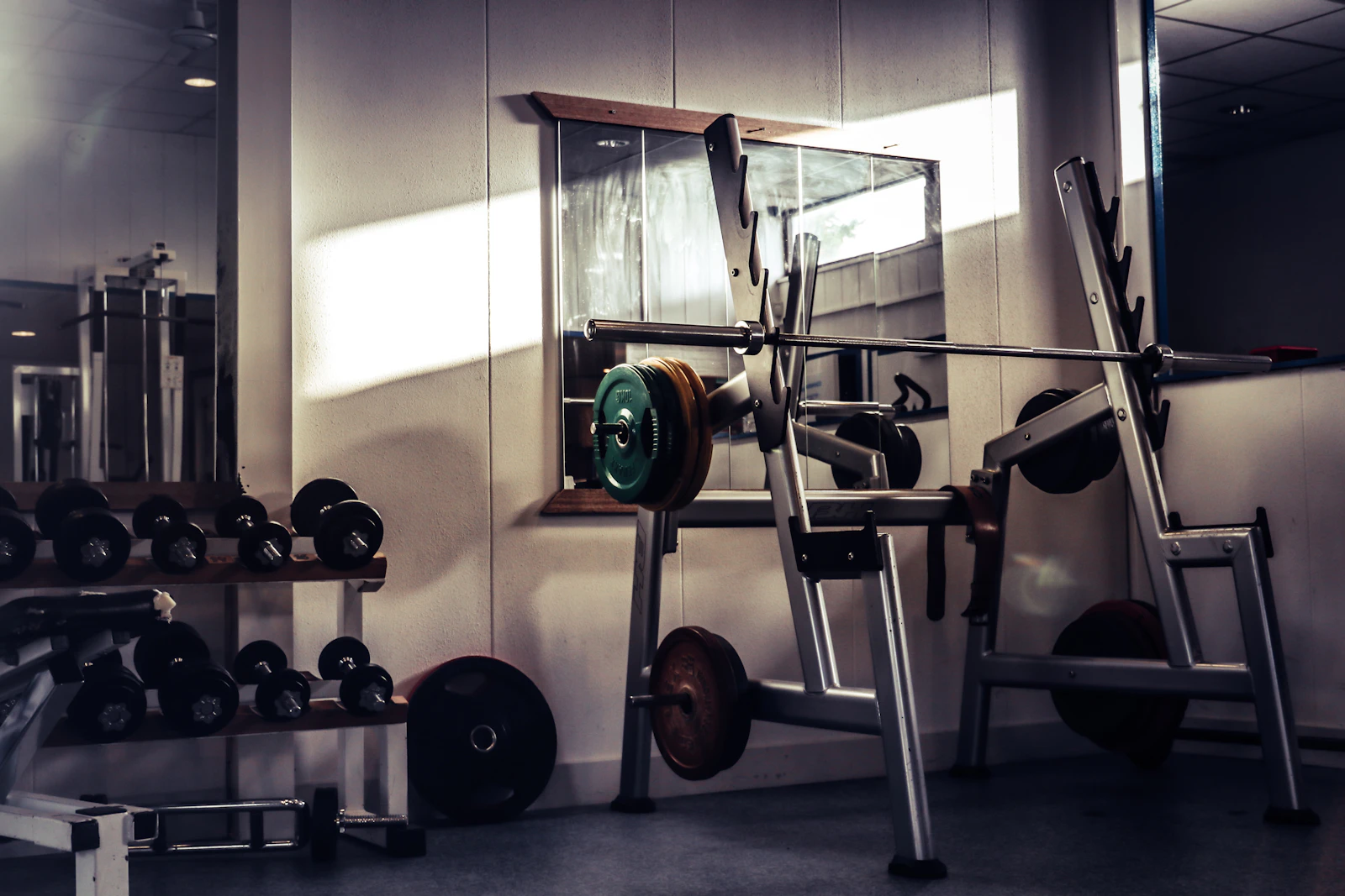 Barra y mancuernas en una sala de entrenamiento