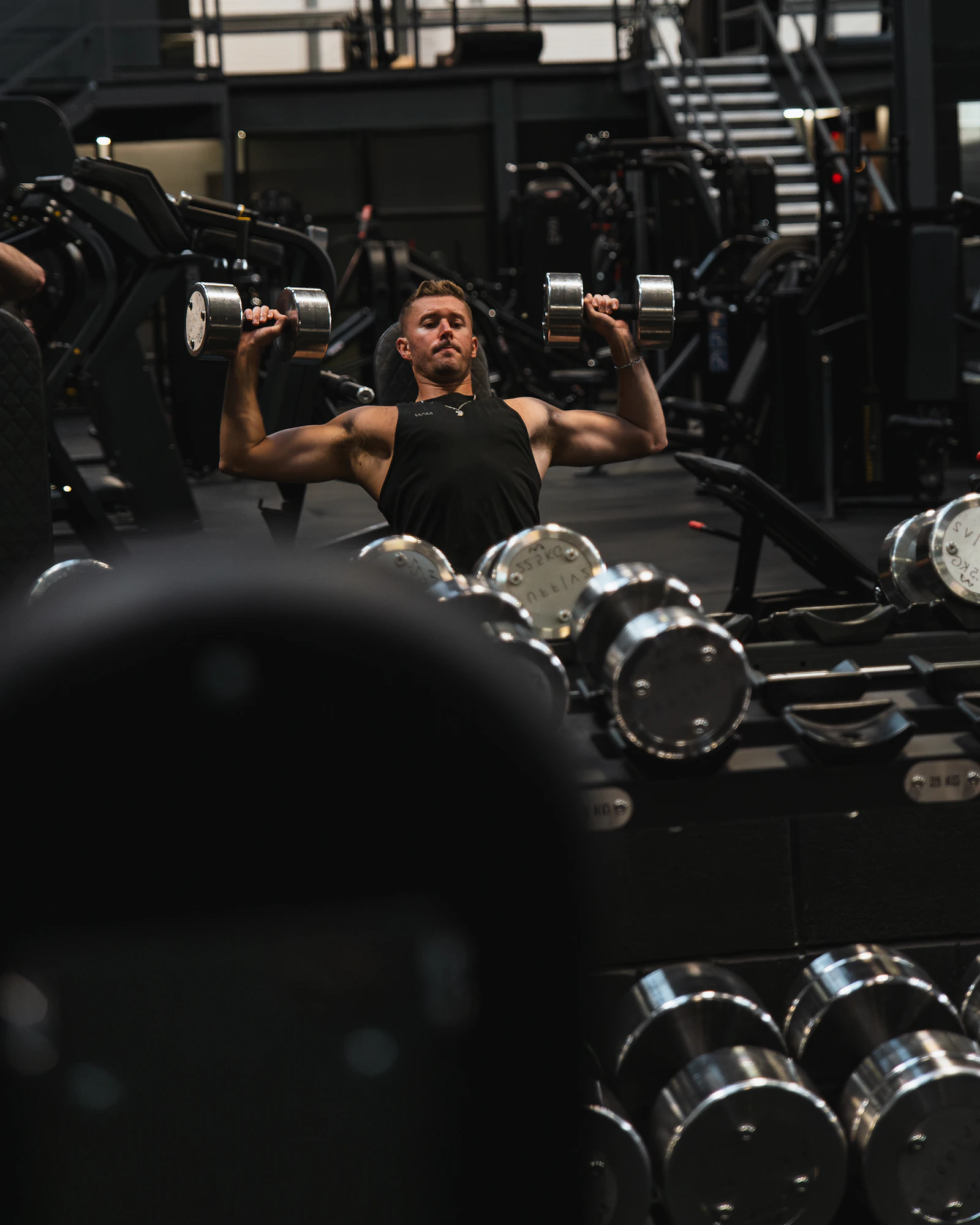Persona entrenando con mancuernas en un gimnasio